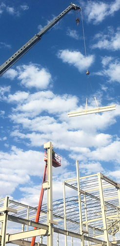Crane lifting a beam for a construction build
