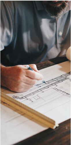 Man designing plans - construction service offered by Watts