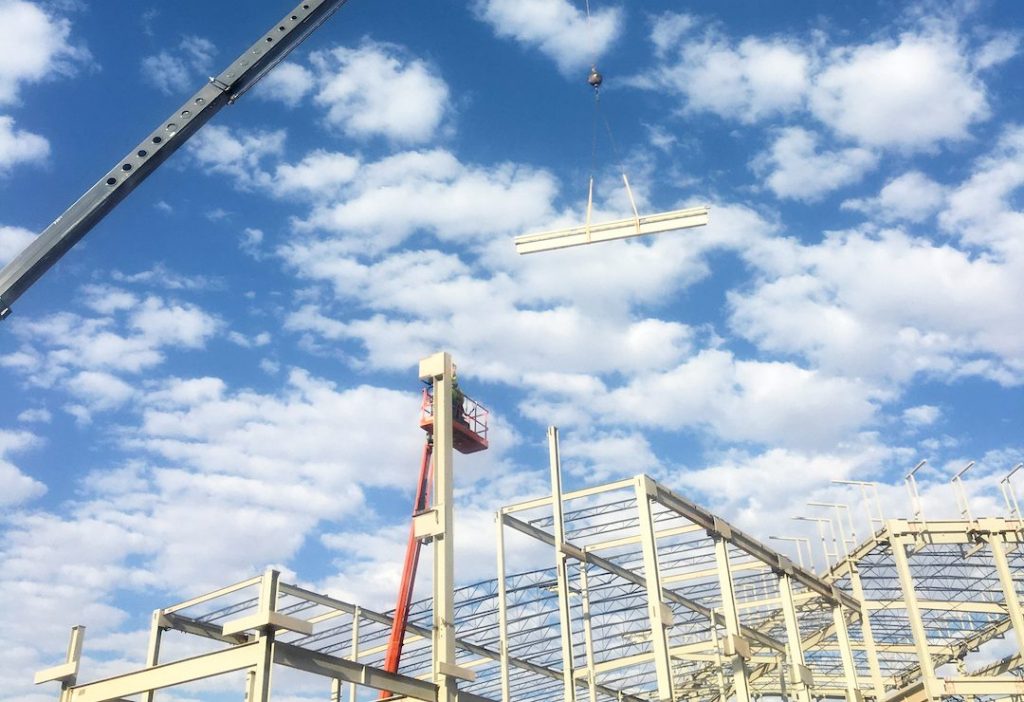 Crane lifting a beam for a construction build