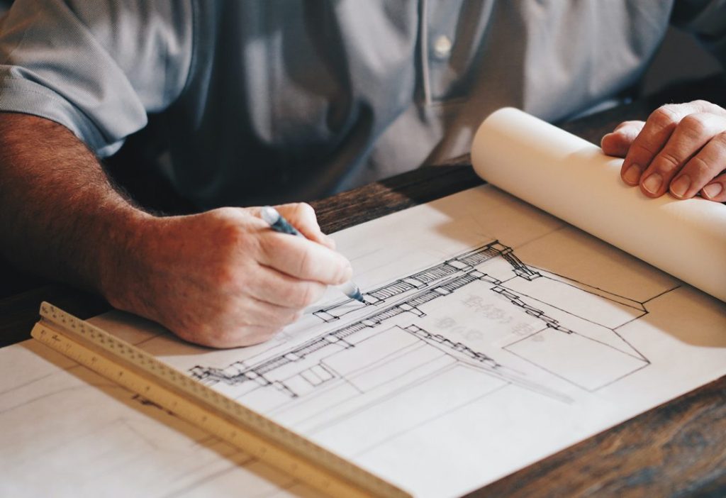 Man designing plans - construction service offered by Watts