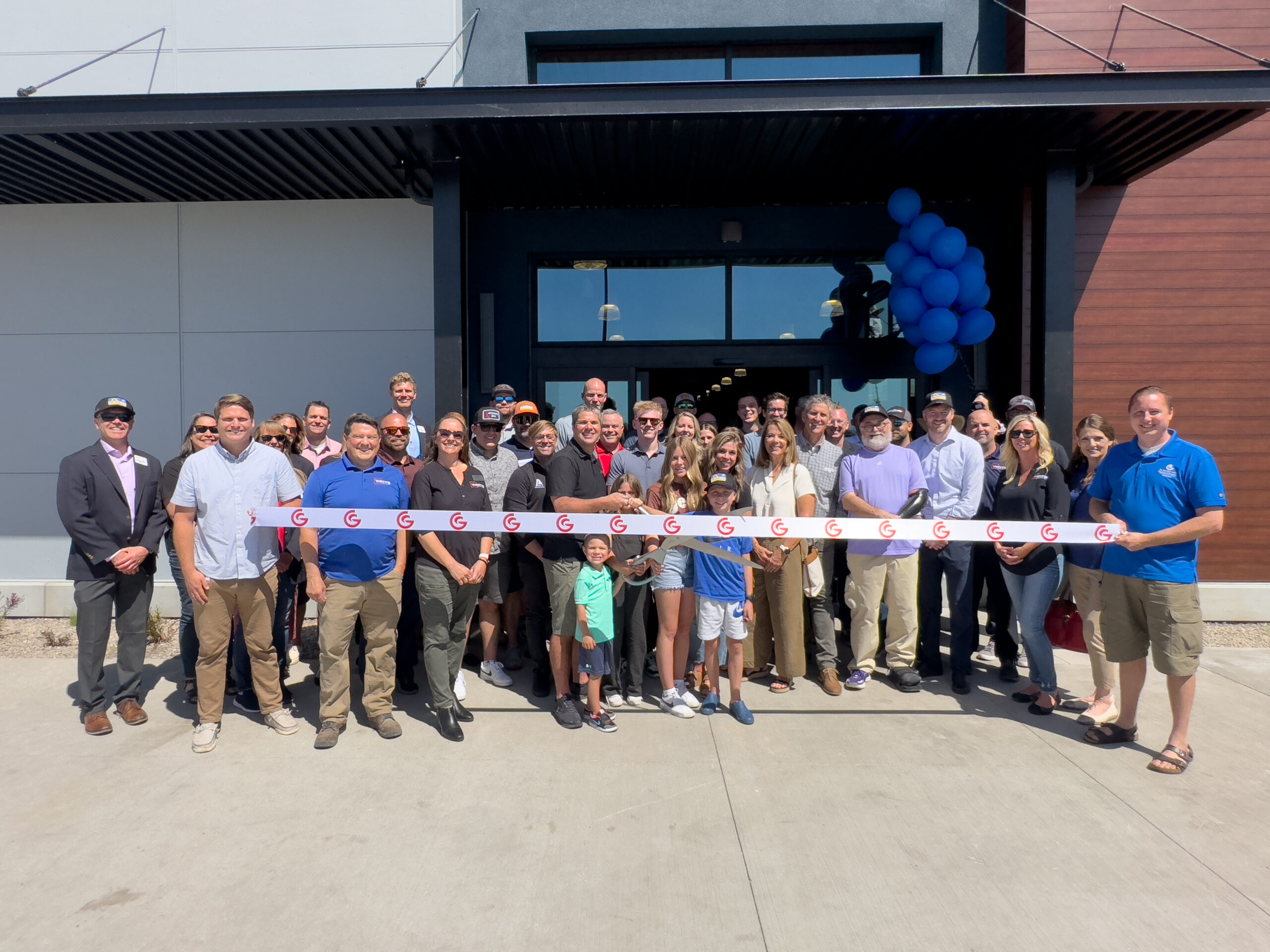 People posed behind a ribbon before it was cut