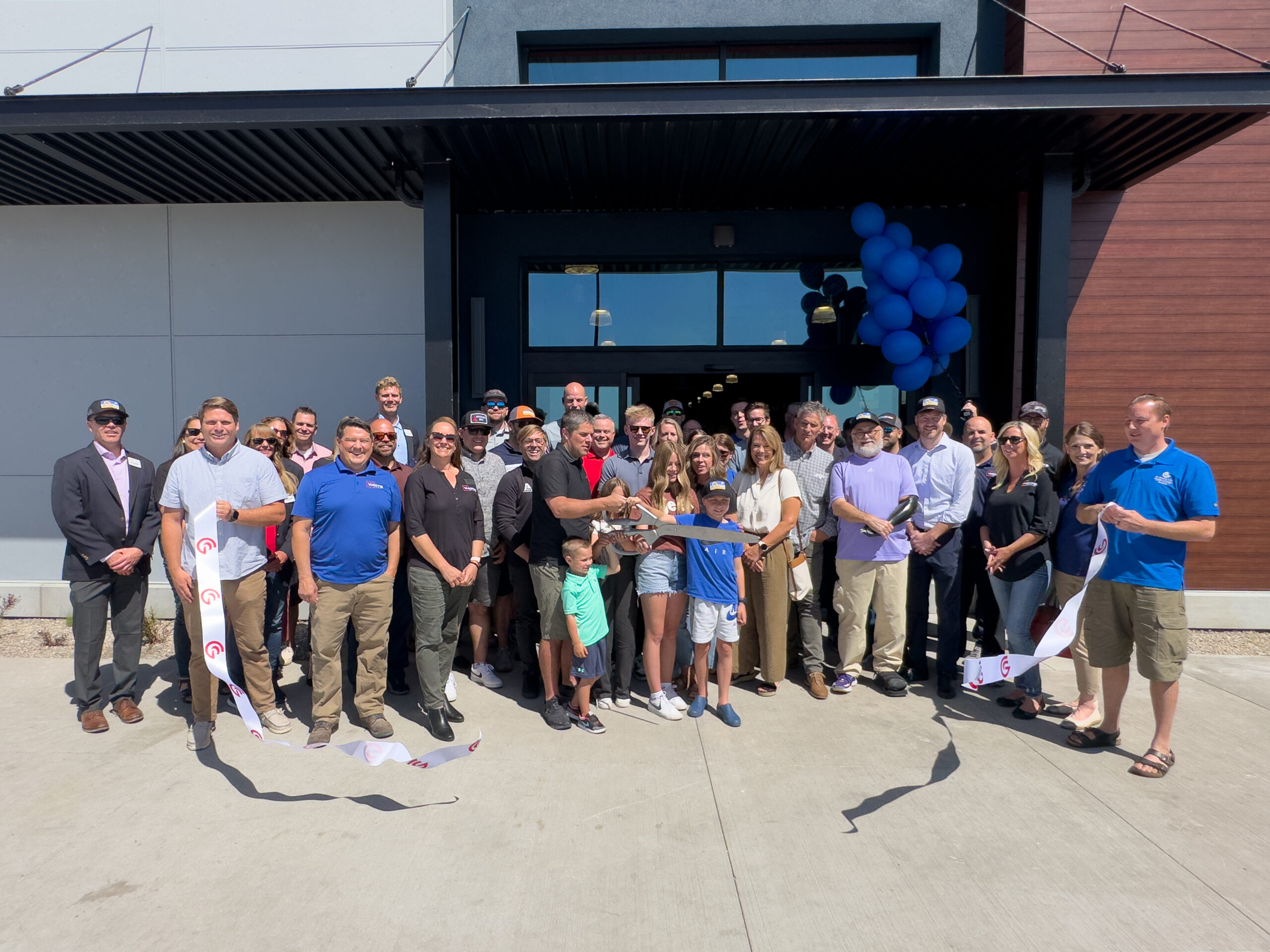 Event attendees pose after Al's owner cuts ribbon